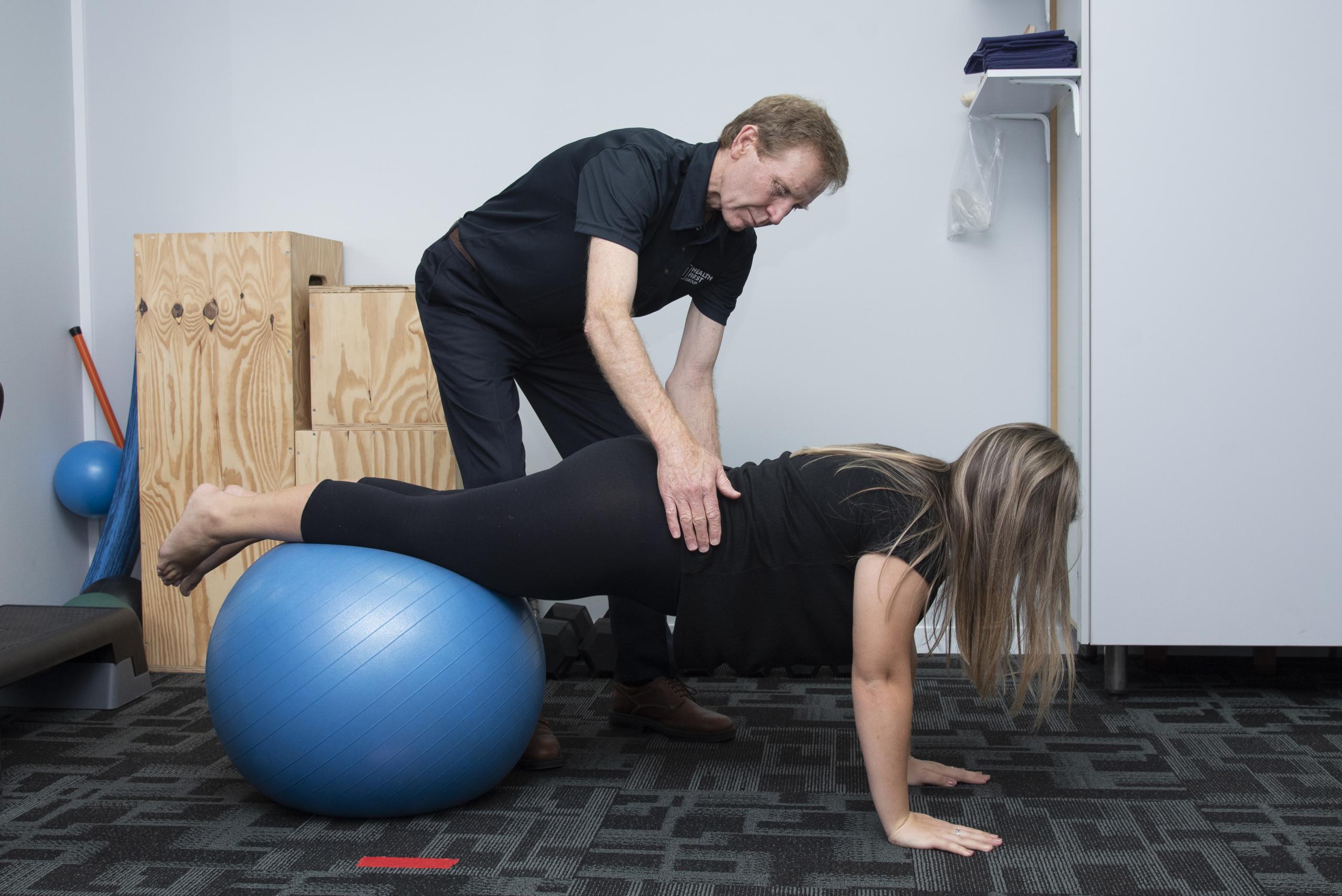 Girl on exercise ball with an Exercise Physiologist