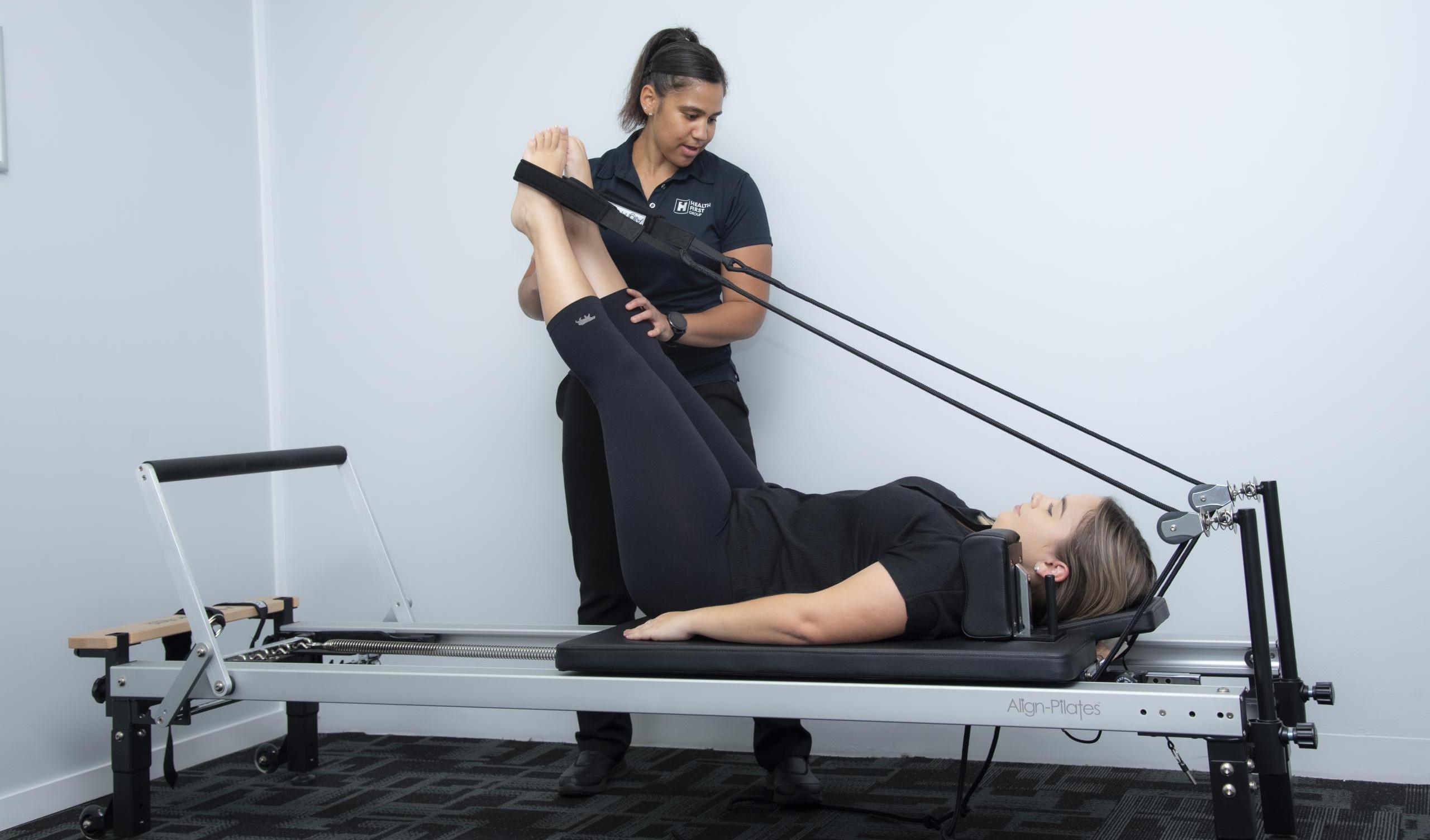 Women on pilates reformer being trained by a physiotherapist