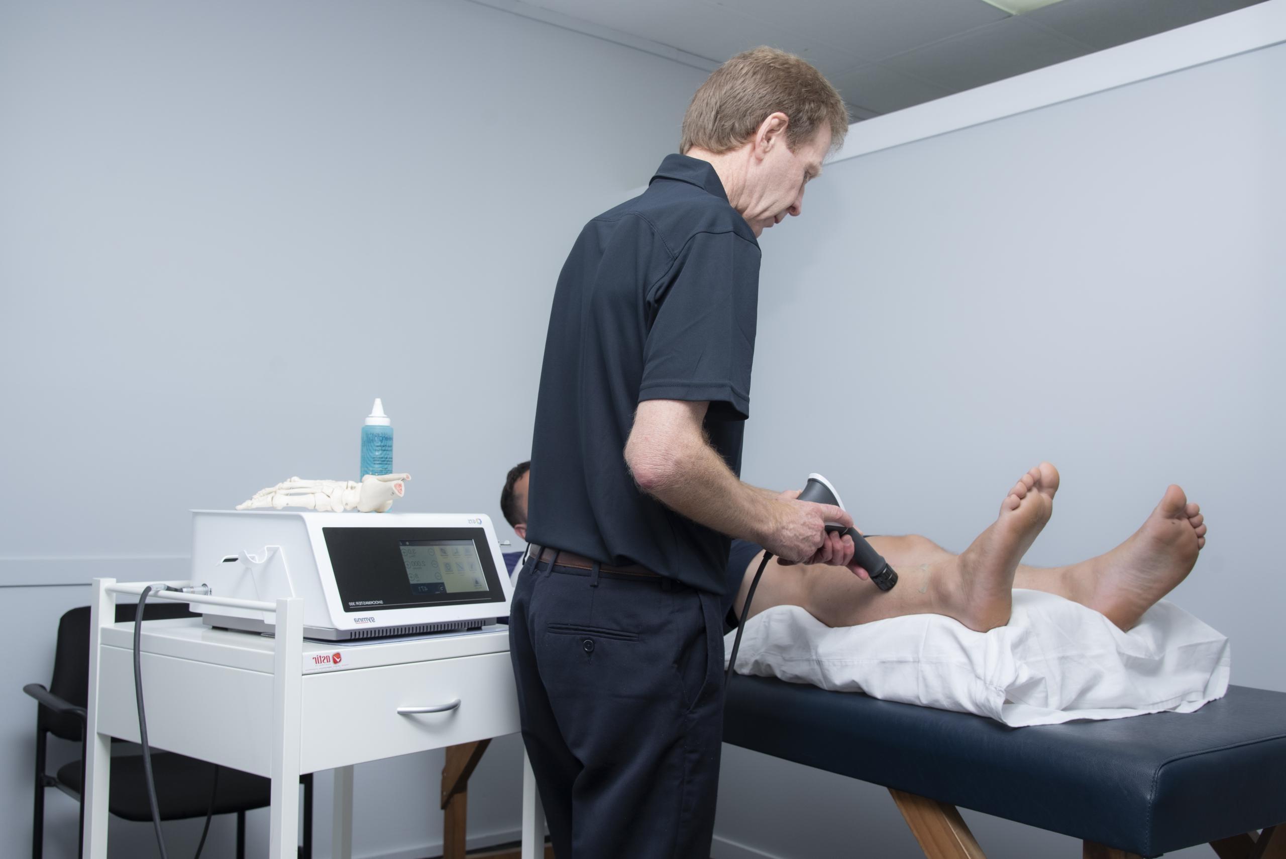 Image showing a physio administering shockwave therapy to a patient