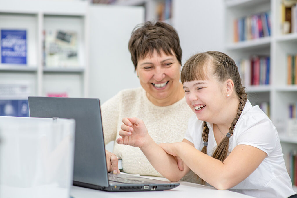 Smiling,girl,with,down,syndrome,is,uses,a,laptop,with