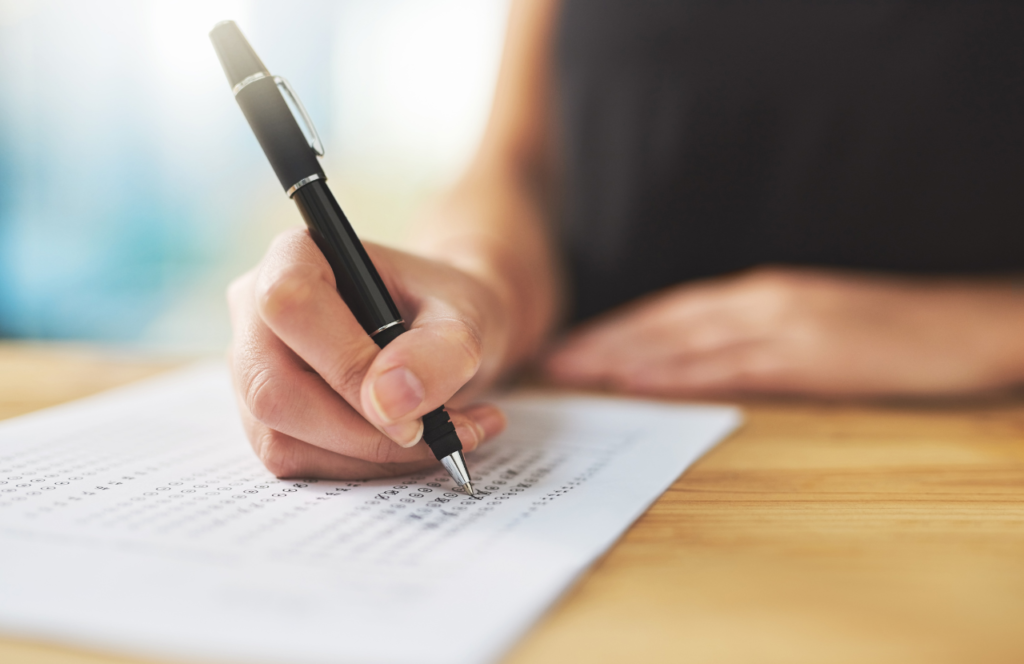 Person completing a functional capacity assessment form with a pen, emphasizing the evaluation process for enhancing independence and support in health services.